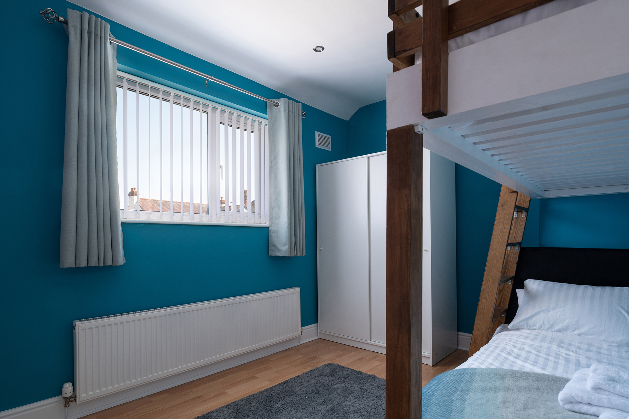Blue bedroom with wooden bunk beds